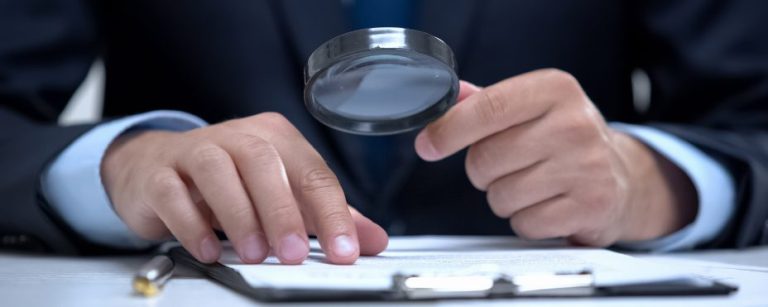 Pessoa lendo um documento em uma lupa